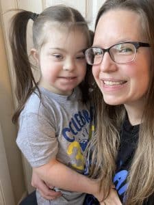 A mom holds her nine-year-old daughter with Down syndrome.