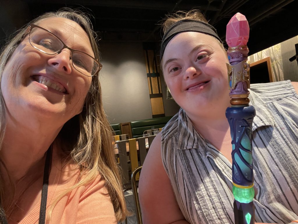 A mother and daughter smile at the camera together.